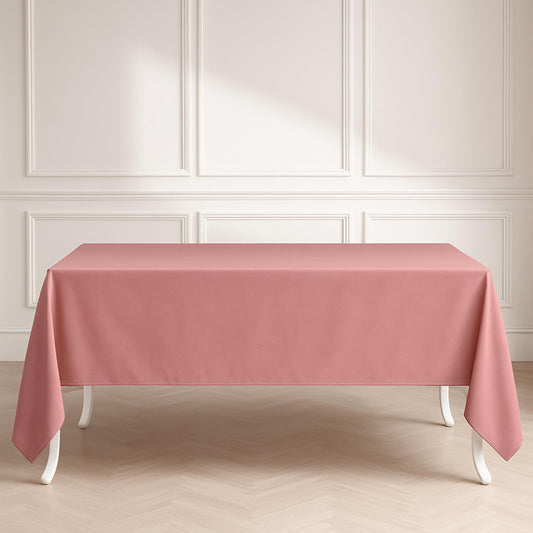 Pink tablecloth on a rectangular table against a white paneled wall.